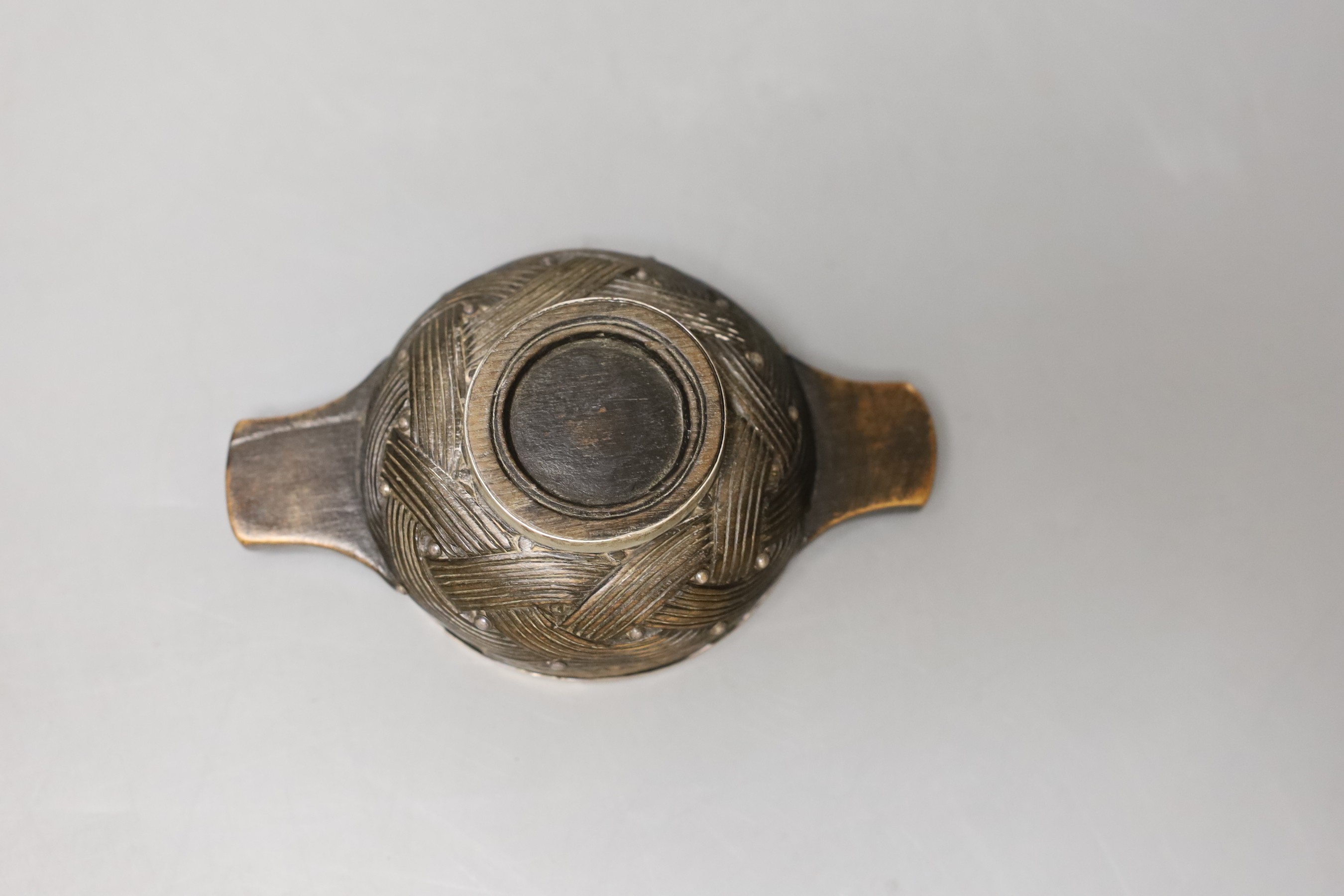 A late 18th/early 19th century white metal mounted wooded quaich, with interwoven carving, unmarked, diameter 11.1cm, (a.f).